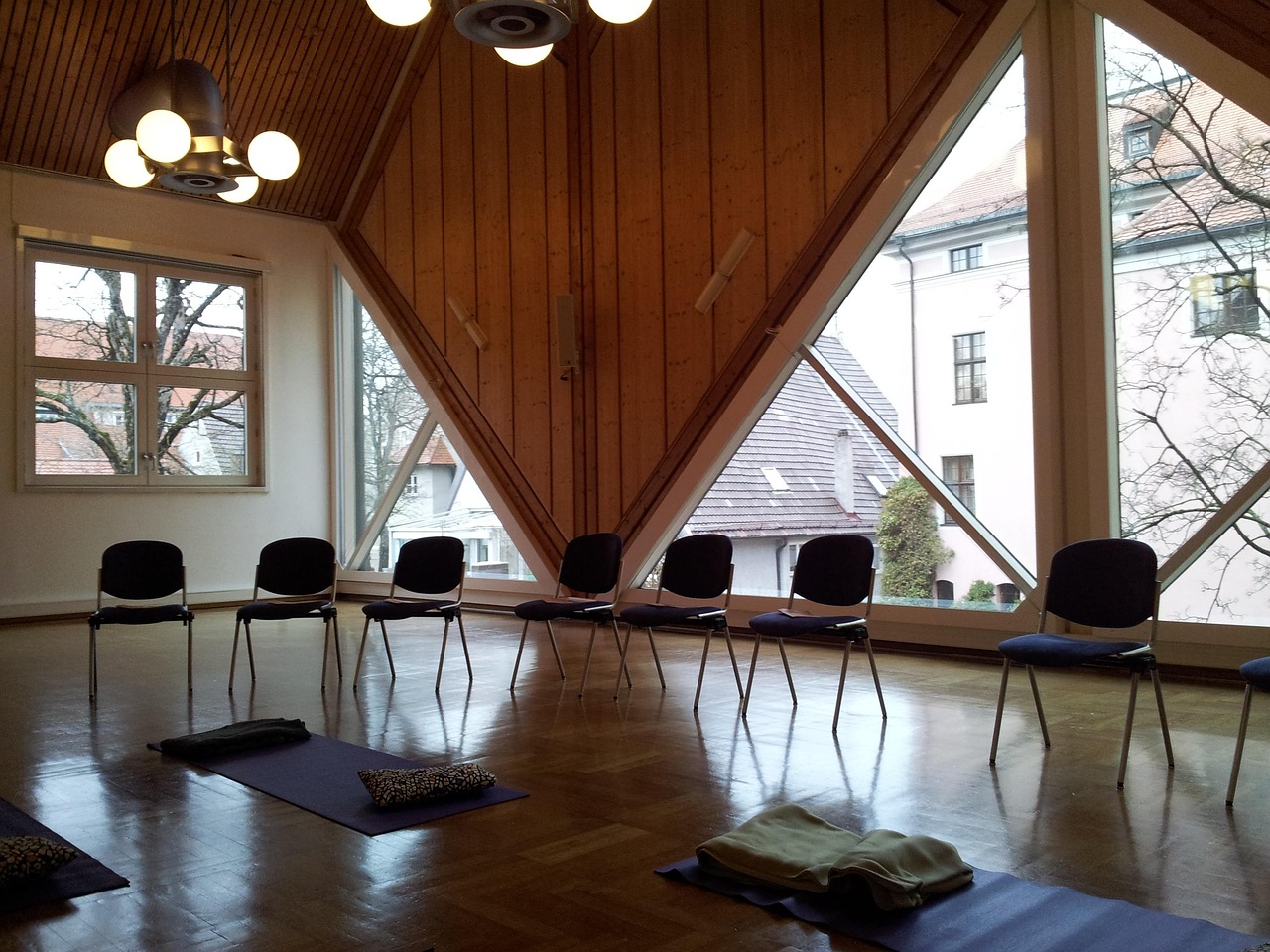 Studio entry with pale wood, a low bench, folded blankets, and daylight